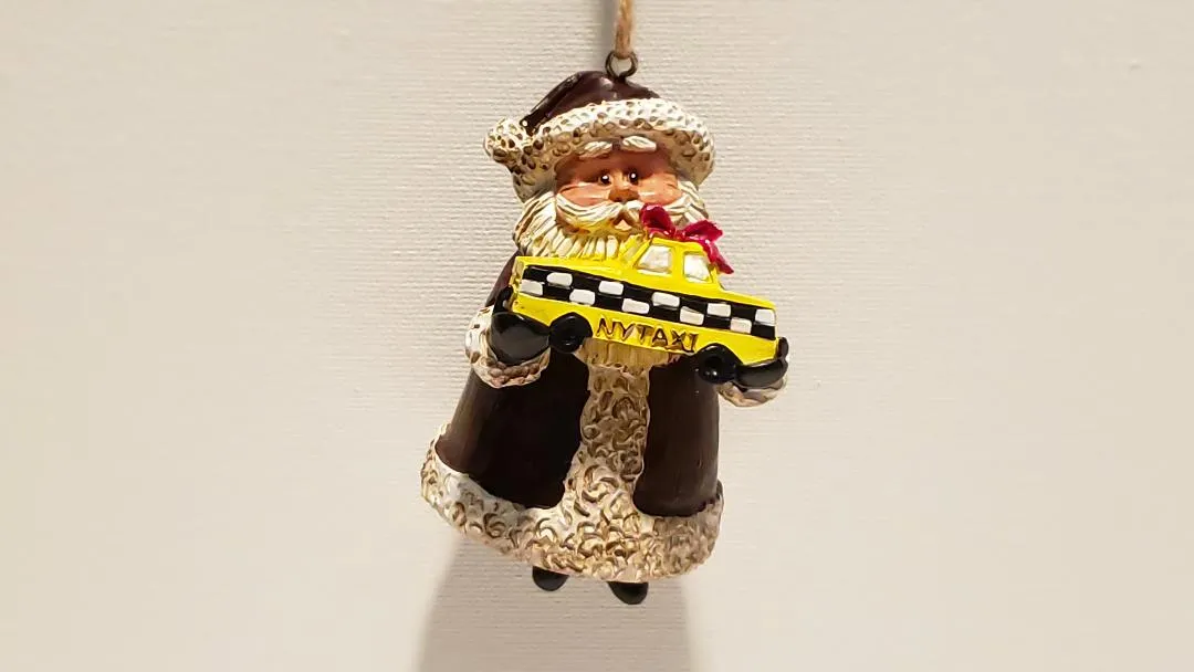 Santa holding a Yellow Cap NYC Taxi Christmas ornament